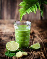 Green herb smoothie with lime ,mint ,ginger on wooden background 