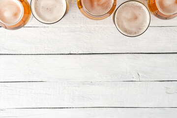 Collection of beer mugs on white wooden table with copyspace. Top view