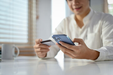 An Asian man using mobile banking application to transfer money