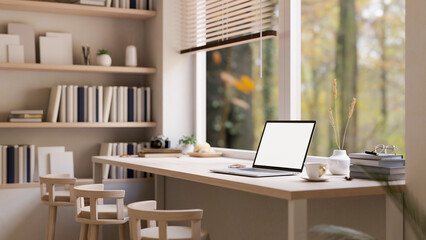 Minimal comfortable workspace with laptop on wood table against the window, stools