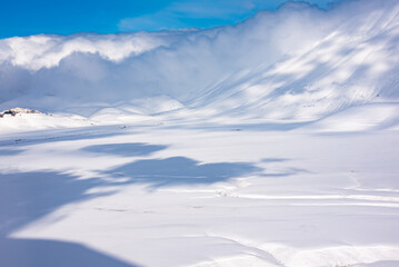Winter landscape, valley and hills covered with snow on bright sunny day