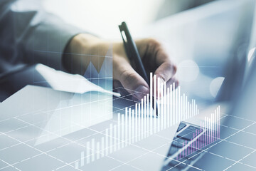Abstract creative financial graph with hand writing in notebook on background, forex and investment concept. Multiexposure