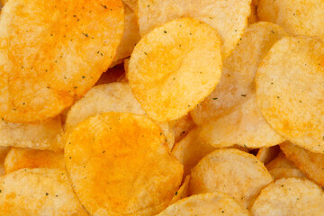 Crispy potato chips with herb seasoning, top view.