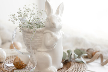 Easter composition with a ceramic hare and gypsophila flowers.