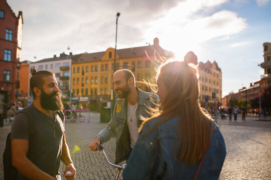 Three smiling friends in town square