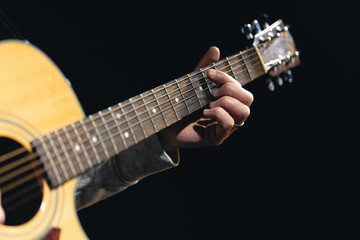A man plays an acoustic guitar, close-up.