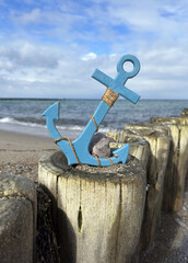 blauer Anker steht auf den Buhnen an der Ostsee am Strand © Ostseeflair
