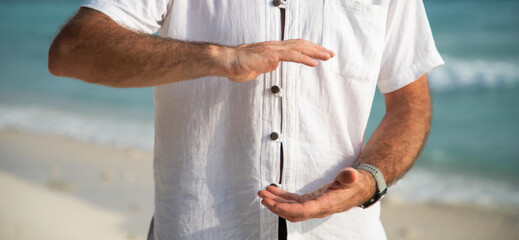 man doing qigong on tropical beach