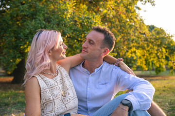 Fototapeta premium Couple in love spend time together at a public park during sunset.