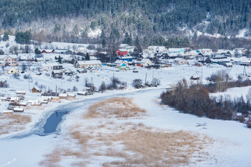 Aerial village view by the river at winter morning.