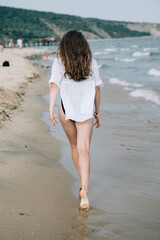 Young slim beautiful woman at sunset 
on the beach.