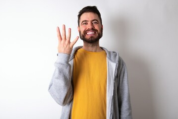 Young caucasian mán wearing trendy clothes over white background smiling and looking friendly, showing number four or fourth with hand forward, counting down