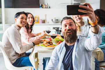 Smiling young boys taking a group selfie during a dinner party