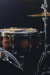 Fototapeta na wymiar Snare drum on a blurred dark background, part of a drum kit.