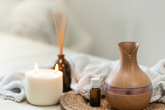 Spa composition with aroma oil diffuser lamp on a blurred background.