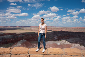 Naklejka premium Smiling blonde young girl with a photo camera in the Petrified Forest National Park
