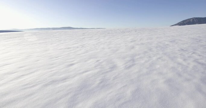 open snowy landscape flying above snow drifts in montana