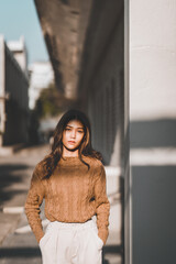 Beautiful Asian woman wearing warm clothes winter and autumn portrait at outdoor in warm light with morning.