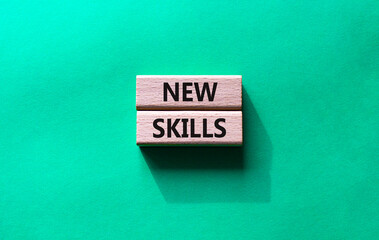 New skills symbol. Wooden blocks with words New skills. Beautiful green background. Business and New skills concept. Copy space.