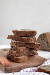 Stack of sliced wholegrain bread on a wooden board. Healthy eating concept. Copy space. Side view.