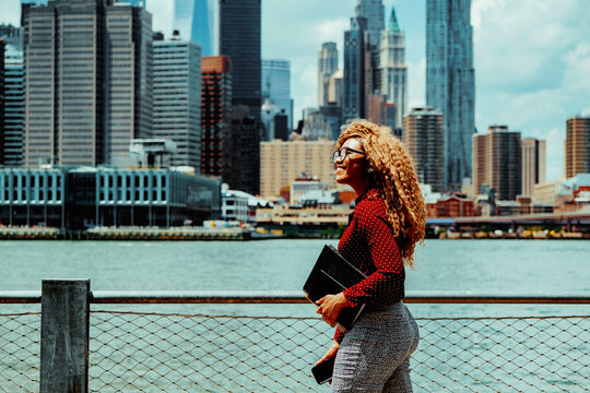 Mid adult woman walking by river in city