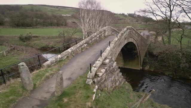 Duck Bridge and adjacent ford over the River Esk - North York Moors in England.
Low level aerial arc - 4K