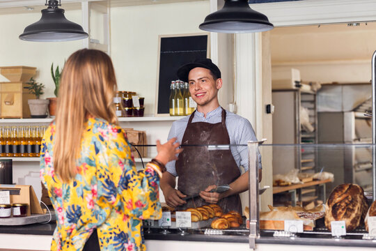 Owner talking with customer in bakery