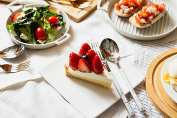 Strawberry slice cake and food on the table
