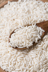 Organic raw sticky rice or glutinous rice in wooden spoon