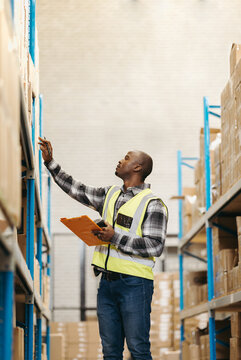 Male logistics worker taking inventory in a warehouse