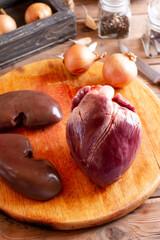 Raw fresh pork heart and kidneys on the table. Offal. Ready to cook.