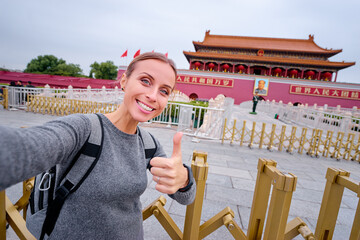 Enjoying vacation in China. Travel and technology. Young woman  taking selfie in Forbidden City,...