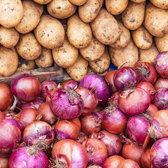 Organic potatoes and dry onions for sale at the local market. Vegan food background.