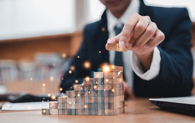 Businessman hand putting placing wood block on the tower and semi-pyramid in modern office. Strategies for playing stocks. Plan business development ideas, investment graph and strategy in business