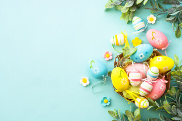 Easter eggs in the nest on blue background. Easter decor, holiday background. Flat lay image with...