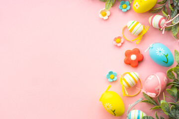Easter background. Eggs, spring leaves and flowers on pink. Flat lay with copy space.