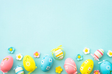 Fototapeta na wymiar Easter eggs and spring decor on blue background. Flat lay with copy space.
