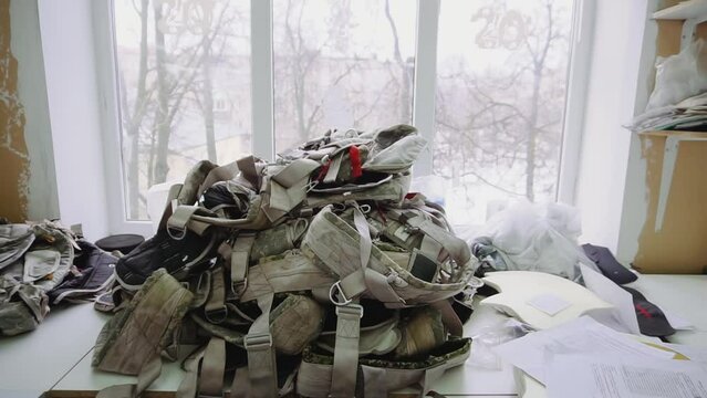 Pile of camouflage parachute rucksacks on table in workshop