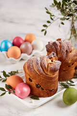 Obraz na płótnie Canvas Traditional Easter Cruffin buns made from yeast dough with raisins covered with sugar powder. Colored Easter eggs. 