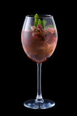 Cold red sangria with dry rosebuds in a wine glass on black background