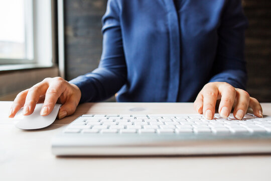 Woman using computer keyboard and mouse