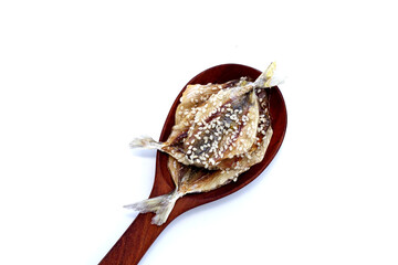Dried fish with sesame seeds on white background.