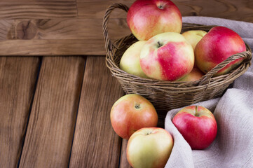 Naklejka na ściany i meble Close-up view of red apples in the basket on wooden background with place for your text