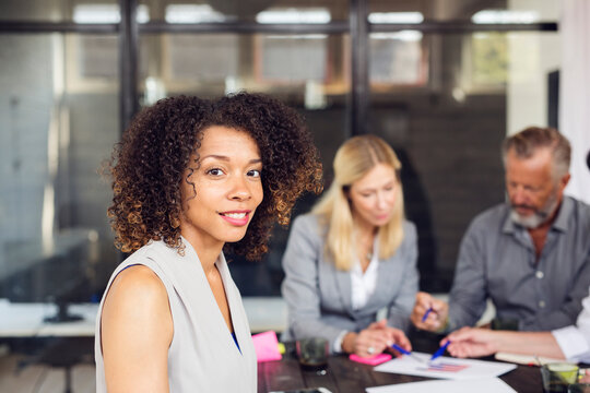 Portrait Of Brunette Woman, Business People Working In Office In Background