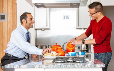 Gay Lifestyle: Breakfast. A same sex, mixed race male couple enjoying breakfast together in their modern home. From a series of related images.