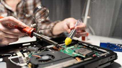 Fototapeta na wymiar an electrical repairman solders a chip