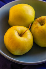 close up yellow apples in a bowl