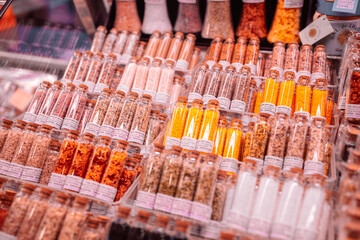 Delicious lemon salt (sal de limon), chili and orange salt (sal de chili naranja) and herbal salt in glass jars on the La Boqueria Market in Barcelona, Spain.