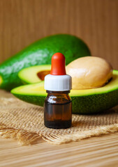Avocado and avocado oil on wooden background. Selective focus