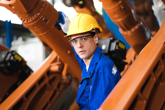 Industrial engineer working on mechanic part orange robot frame before assembly to smart automation machine. Industry 4.0 is robotization technology in modern factory. Robotics engineering concept.